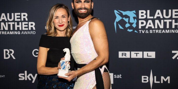 Producerin Anna-Lena Zwez und Conchita Wurst vor der Pressewand bei der Preisverleihung 2022. Beide die Hand an der Panther Statue.