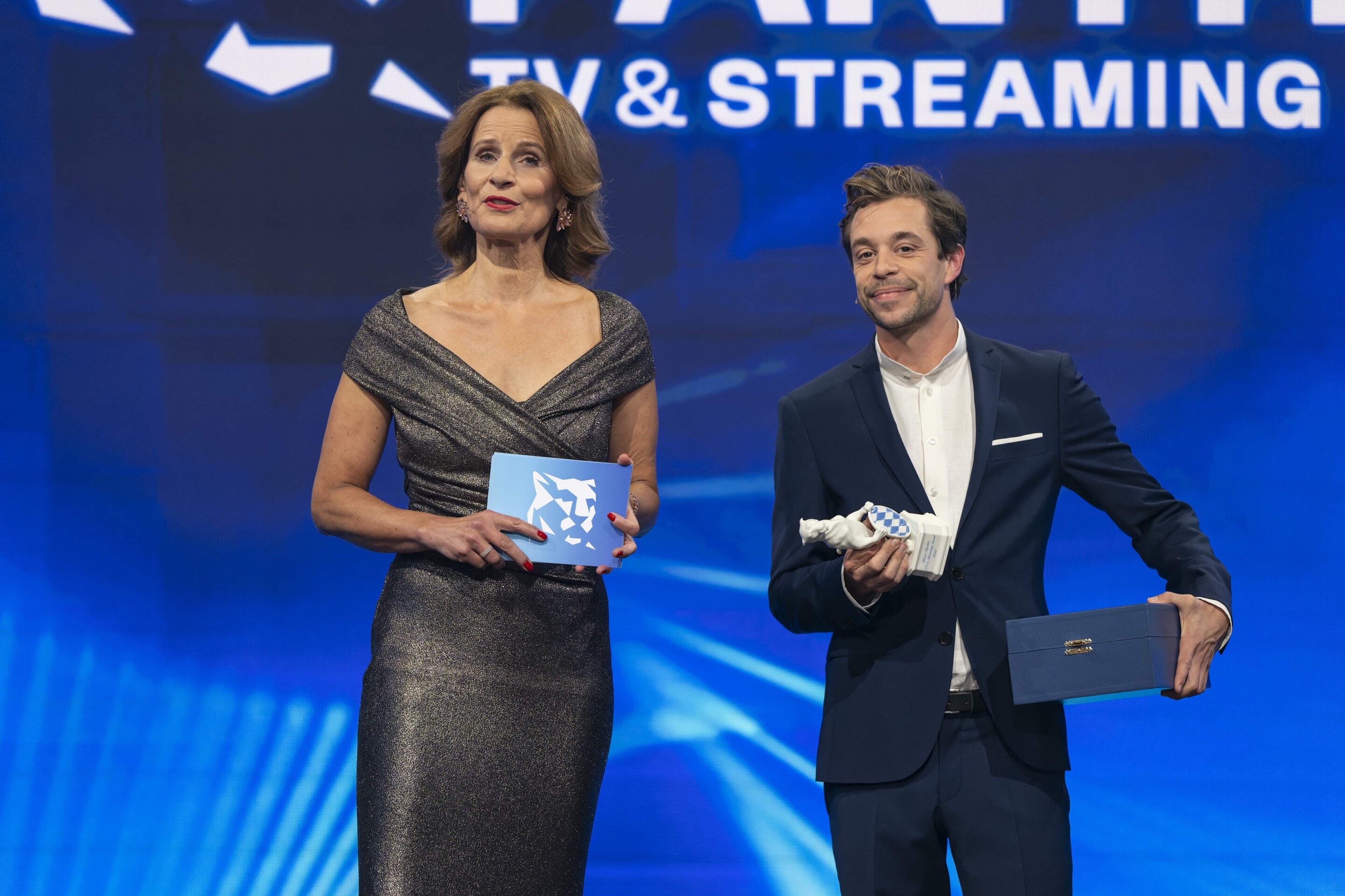 Auch dieses Jahr wieder live vor der Panther-Kamera: Katrin Müller-Hohenstein und Tobias Krell führen am 25. Oktober 2023 zum zweiten Mal durch die Award Show (c) Medien.Bayern – Ralf Wilschewski