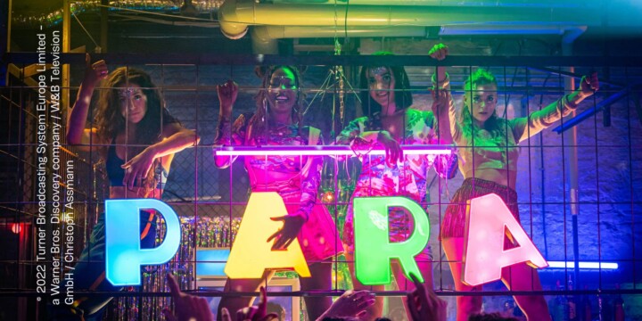 In einem Club stehen vier Frauen au feiner Erhöhung. Vor jeder Frau steht ein Leuchtbuchstabe - zusammen ergeben sie "PARA". Rundherum werden sie von einem Publikum bejubelt