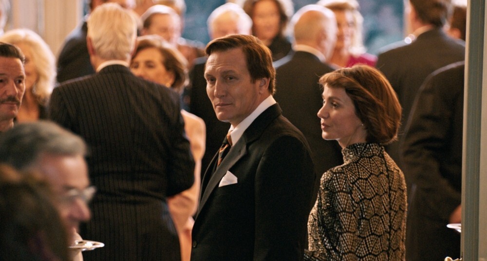 TV & Streaming Tipps im Oktober: Ein Herr und eine Frau in festlicher Kleidung in einem Saal voller Menschen