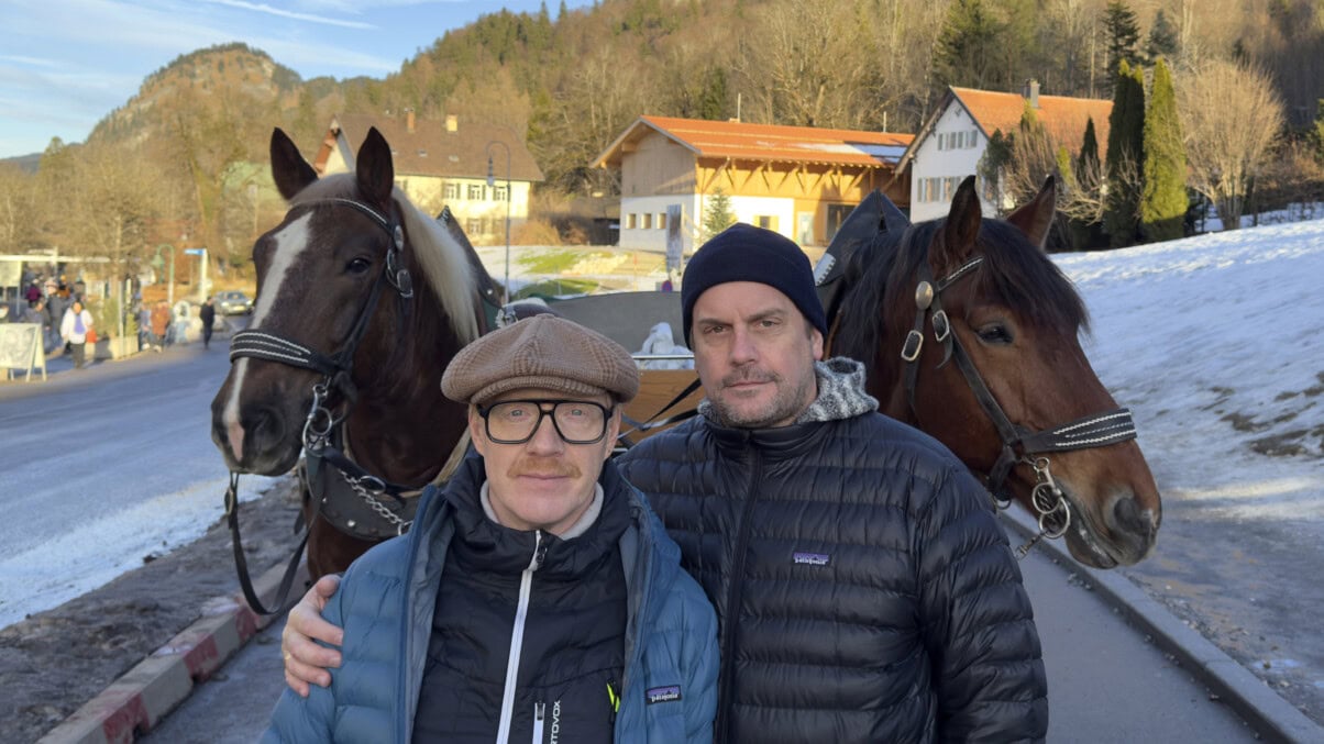 Simon Schwarz und Sebastian Bezzel stehen vor Schloss Neuschwanstein.
