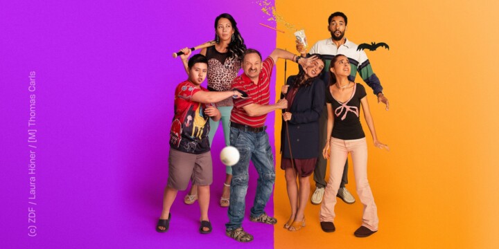 Zwei Familien stehen nebeneinander. Jede Familie besteht aus Mutter, Vater und Kind: Einmal mit einer Tochter, einmal mit einem Sohn. Die Familie auf der linken Seite steht vor einem lila Hintergrund, die andere vor einem Orangenen Hintergrund. Beide Familien scheinen gegeneinander zu kämpfen, ein paar der Personen schauen entsetzt oder verwirrt. Die Stimmung scheint angespannt, aber auch überzogen und dadurch auch humorvoll.