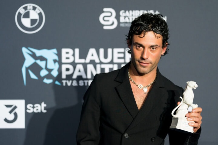 A man holding an award at the bluer panther awards.