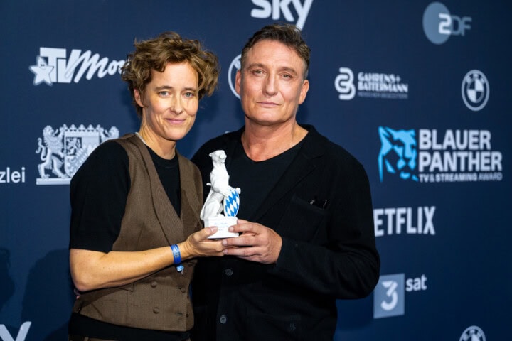 Pia Strietmann (l.) gewinnt den Blauen Panther 2025 in der Kategorie Fiktion für die Regie der Serie „Herrhausen - Der Herr des Geldes“ (Sperl Film & Fernsehproduktion GmbH/ X Filme Creative Pool/ ARD Degeto Film/ RBB/ SWR/ HR für die ARD). Die Laudatio hielt Oliver Masucci (r.).